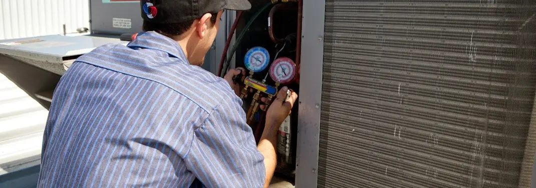 HVAC technician servicing a condenser unit in Circleville
